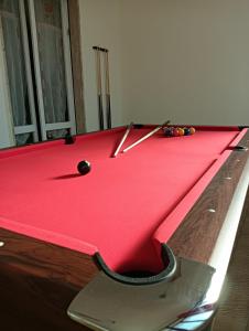 een rode pooltafel met speelballen erop bij Ca`del Fuin in Seregno