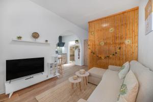 a living room with a white couch and a television at Casa Barriguita El Golfo in El Golfo