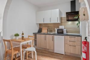 a kitchen with white cabinets and a table with chairs at Casa Barriguita El Golfo in El Golfo