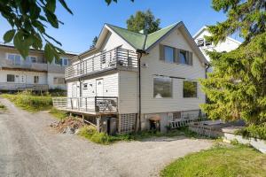 ein Haus, das auf einer unbefestigten Straße liegt in der Unterkunft Northstay - Tromsø Urban Retreat - Free Parking, Brand New & Modern in Tromsø