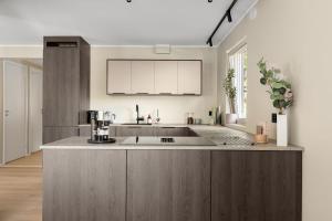 eine Küche mit einer großen Insel in der Mitte in der Unterkunft Northstay - Tromsø Urban Retreat - Free Parking, Brand New & Modern in Tromsø