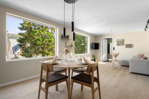ein Esszimmer und ein Wohnzimmer mit Tisch und Stühlen in der Unterkunft Northstay - Tromsø Urban Retreat - Free Parking, Brand New & Modern in Tromsø