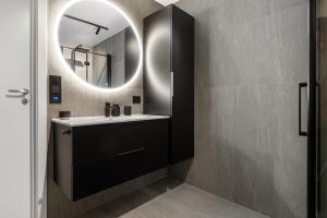 ein Badezimmer mit Waschbecken und Spiegel in der Unterkunft Northstay - Tromsø Urban Retreat - Free Parking, Brand New & Modern in Tromsø + 15 Fotos