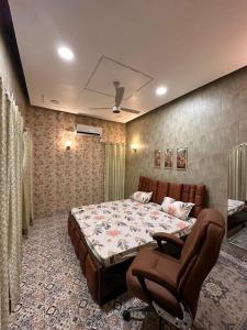 een slaapkamer met een bed en een stoel erin bij Royal Heritage in Lucknow