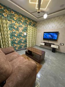 een woonkamer met een bank en een tv bij Royal Heritage in Lucknow +5 foto's