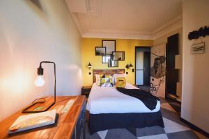 una camera da letto con un letto grande e una scrivania di Madrigal a Parigi