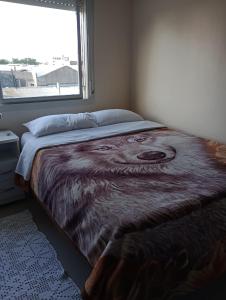 a bed in a bedroom with a large window at Belo apartamento no 4 distrito Porto Alegre in Porto Alegre