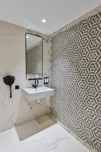 un bagno con lavandino e specchio di Madrigal a Parigi