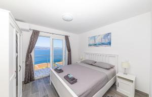 a bedroom with a bed with a view of the ocean at 2 Bedroom Stunning Apartment In Stanici in Stanići