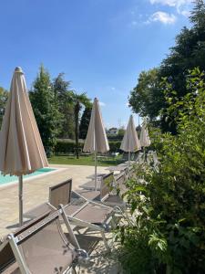 een rij stoelen en parasols naast een zwembad bij Nico's apartment in Sirmione