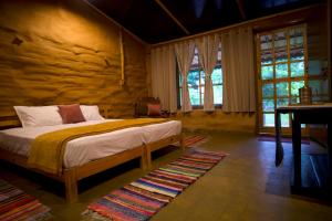 a bedroom with a bed and a wooden wall at Sparrow Woods Eco Resort in Nainital