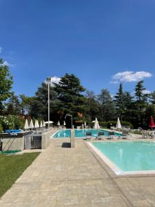 een zwembad met ligstoelen en parasols bij Nico's apartment in Sirmione