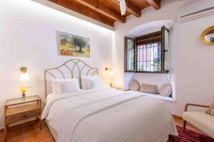 a white bedroom with a large bed and a window at La Morada Mas Hermosa in Marbella