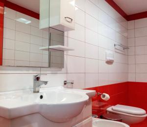 a bathroom with a white sink and a toilet at Paris Luxury Penthouse in Sarandë +36 photos