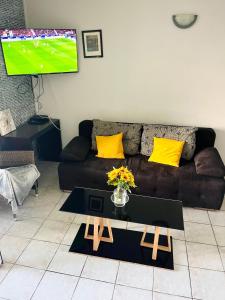 a living room with a couch and a table with yellow pillows at Marina Sun Tropic in Le Marin +10 photos