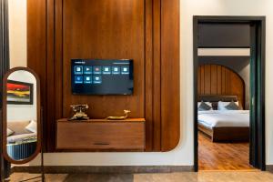 a bedroom with a bed and a television on a wall at Cascade Resorts Ghawari, Gilgit-Baltistan in Kuru