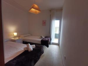 a hotel room with two beds and a window at Apartamento en Platja d'Aro: A/C, Parking, a 2 Pasos de la Playa, 3 Hab, Terraza. - ES-209-12 in Platja  d'Aro