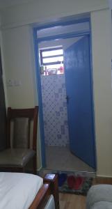 a blue door in a room with a chair at Haven Studio in Ongata Rongai 
