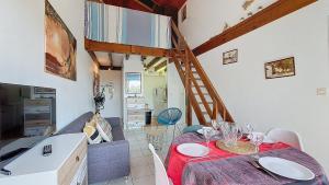 a room with a table and a kitchen with a staircase at V- Tamaris Appartement centre vieux boucau 4 personnes in Vieux-Boucau-les-Bains +1 photo