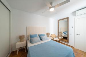 a bedroom with a blue bed and a mirror at Bahía Sol in San José