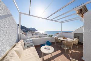 a balcony with a couch and a table and the ocean at Bahía Sol in San José