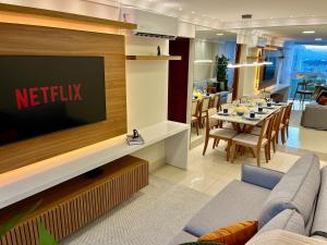 a living room with a television and a dining room at PRAIA Mar Sofisticado Novo in Vila Velha