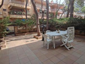 普拉加德阿罗Apartamento con terraza a metros de la playa y zona comercial, ideal familiar - Costa Brava - ES-209-68的露台上的白色桌子和椅子