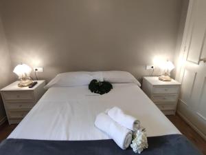 普拉加德阿罗Apartamento con terraza a metros de la playa y zona comercial, ideal familiar - Costa Brava - ES-209-68的卧室里有一张白色的床，床上放着毛巾