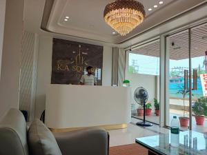 a living room with a chandelier and a large white screen at Hotel K A Square in Bhopal +92 photos