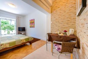a bedroom with a bed and a table and a desk at Apartments Milić in Mlini