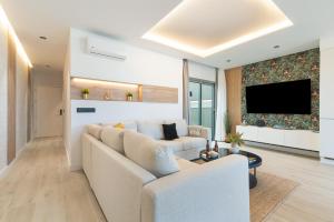 Una sala de estar con un sofá y un televisor. en Home2Book Stylish Beachfront Escape, en Arinaga