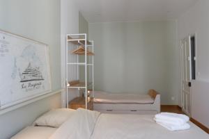 a white bedroom with a bed and a chair at T h e - P L A I C E in Wimereux