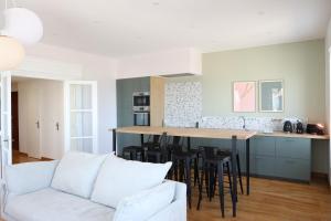 a living room with a white couch and a kitchen at T h e - P L A I C E in Wimereux