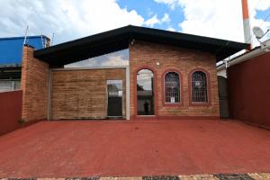 a brick building with a red driveway at MR11 Guest House in Campinas