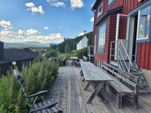 a wooden deck with benches and a building at Prästgården i Funäsdalen in Funäsdalen
