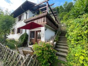 a house with stairs leading up to it with a red umbrella at Landhaus - In der hohen Eich Eg in Überlingen
