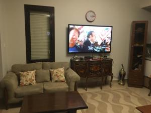 エル・アラメインにあるMarassiのソファと薄型テレビのあるリビングルーム