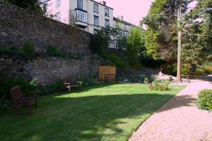 un jardín con bancos y una pared de ladrillo en The Hand Hotel, en Llangollen