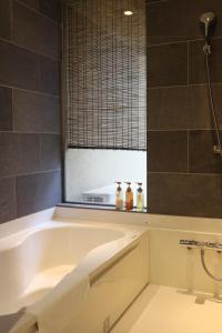 关西国际机场Kansai Airport Hotel Pine Villa的浴室里有浴缸和窗户 更多42张照片