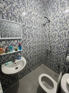 a bathroom with a toilet and a sink at Appartement À Martil in Martil