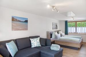 ein Wohnzimmer mit einer Couch und einem Bett in der Unterkunft Ferienwohnung Wankblick in Farchant