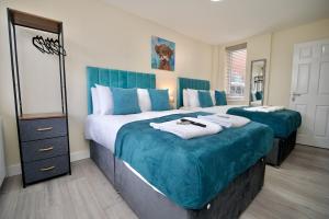a bedroom with two large beds with blue covers at Warwick Row Apartments Coventry City Centre - Flat 3 in Coventry +7 photos
