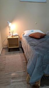 a bedroom with a bed and a table with a lamp at Pousada Vida & Brisa in Pelotas