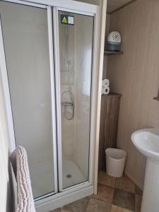 巴德利索尔特顿Elms Caravan with sea views at Devon Cliffs的带淋浴、马桶和水槽的浴室