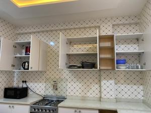a kitchen with white cabinets and a stove top oven at Avexia in Ashalebotwe