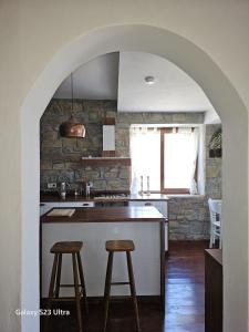 un arco en una cocina con barra y taburetes en Villa Toscana, en Gökçeada
