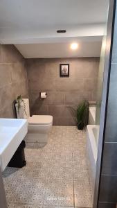 a bathroom with a toilet and a sink and a tub at Quakers Field View in Pennington +19 photos