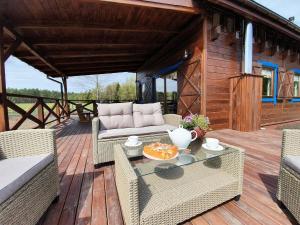 a patio with a couch and a table and chairs at Siedlisko Ptasie Trele 2 in Jerutki