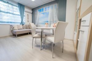 Un comedor con una mesa y sillas blancas. en Tevi Apartments, en Varna 31 fotos más