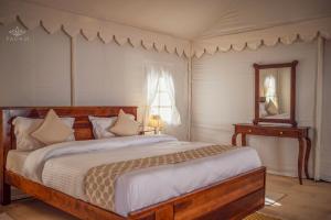 a bedroom with a large bed and a mirror at Padam Jaisalmer in Jaisalmer